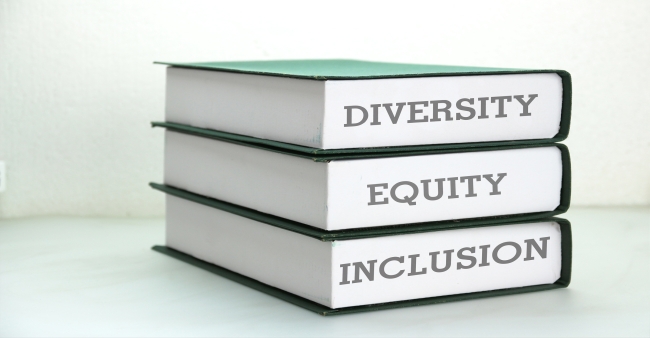 A stack of three books, stamped with the words "Diversity," "Equity" and "Inclusion."
