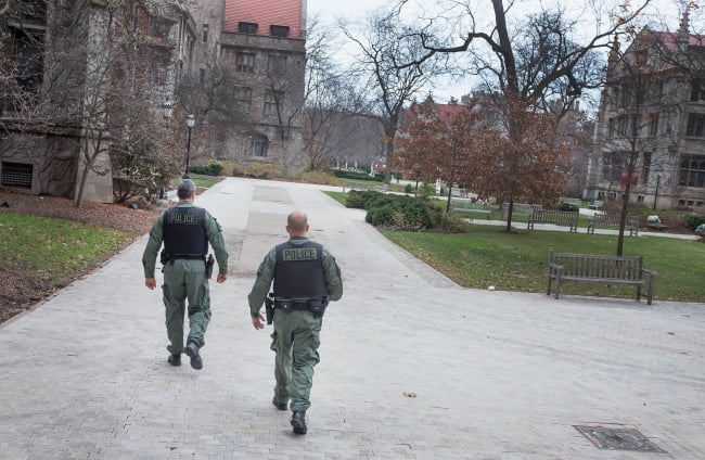 Two police officers walk through the University of Chicago campus.