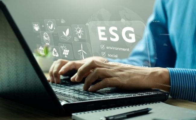 Photo illustration of a person typing on a computer with graphic overlay reading "environmental, social, governance."