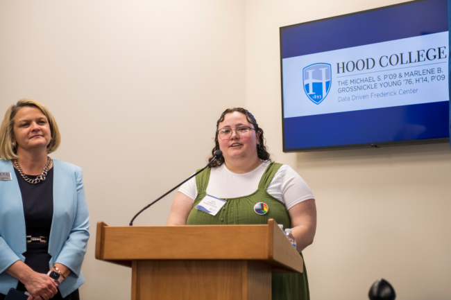 Fourth-year student Anna LePlatt gives a speech at the opening of the Data Driven Frederick Center as Hood College president Andrea Chapdelaine watches.