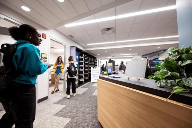 A student talks with April Belback in the door frame of her office at the University of Pittsburgh's student success hub.