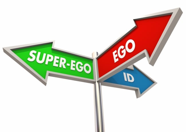 A series of three different-colored street signs, each pointing different ways, each reading, respectively, "SUPER-EGO," "EGO" AND "ID."