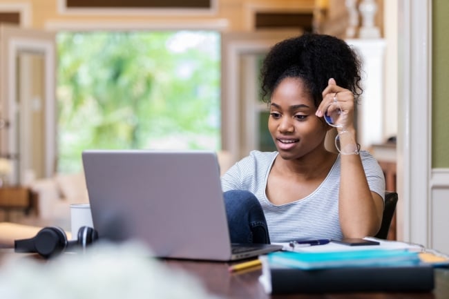 A student works on an open laptop.