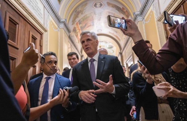 Speaker Kevin McCarthy surrounded by reporters holding smartphones