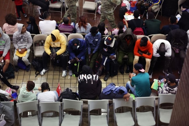 Migrants sit in New York City's Port Authority bus terminal.