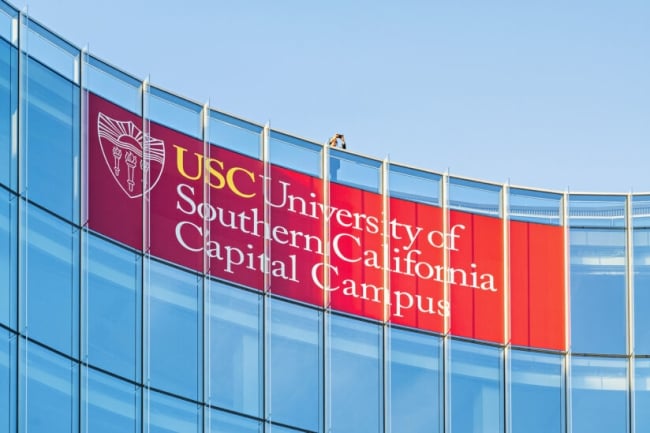 A red sign with text on a glass building.