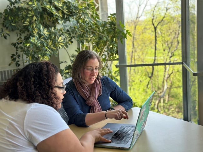 Calley Stevens Taylor works with a student on their laptop.