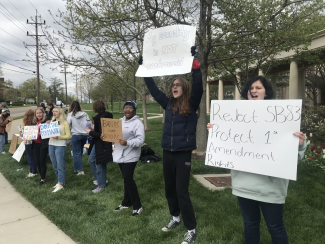 Students holding signs in opposition to Ohio Senate Bill 83