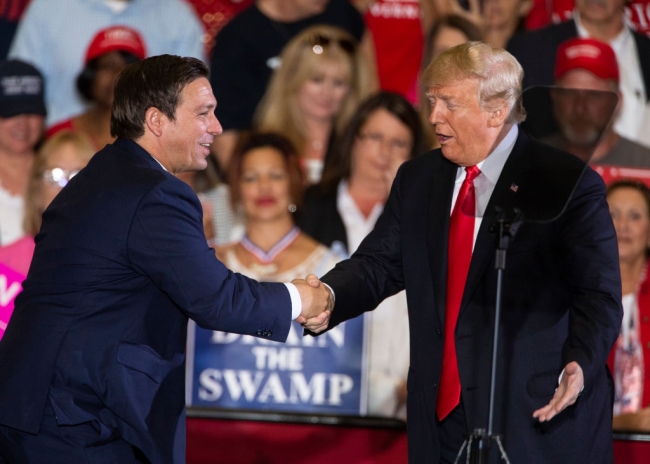 A photo of Ron DeSantis and Donald Trump shaking hands in 2018