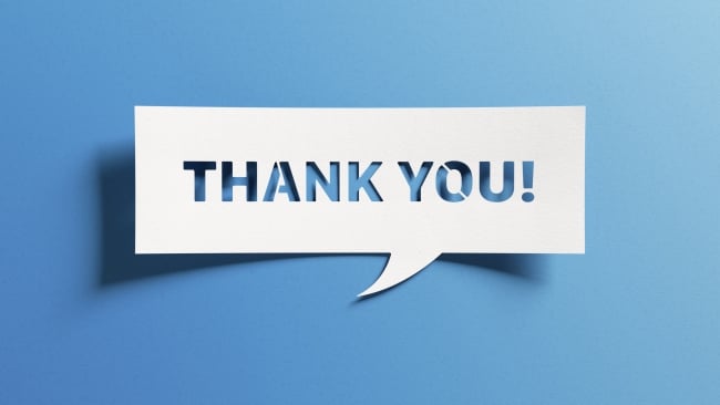 White text bubble–style sign on a blue background says, "Thank you!"