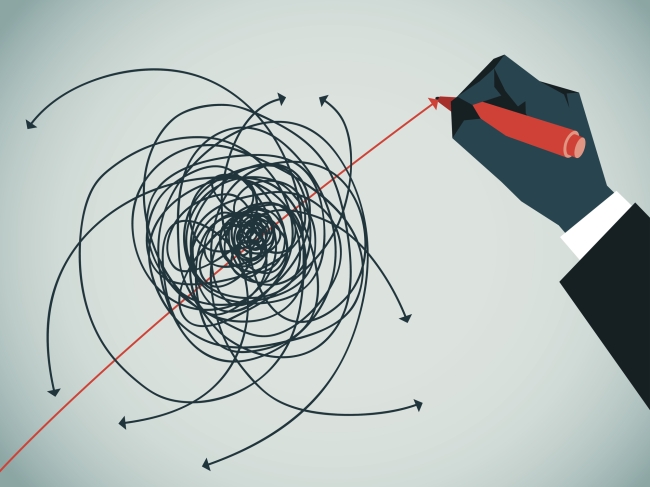A hand with a red pen reaches out and strikes out a bundle of lines all confused and incomprehensible in a type of messy ball