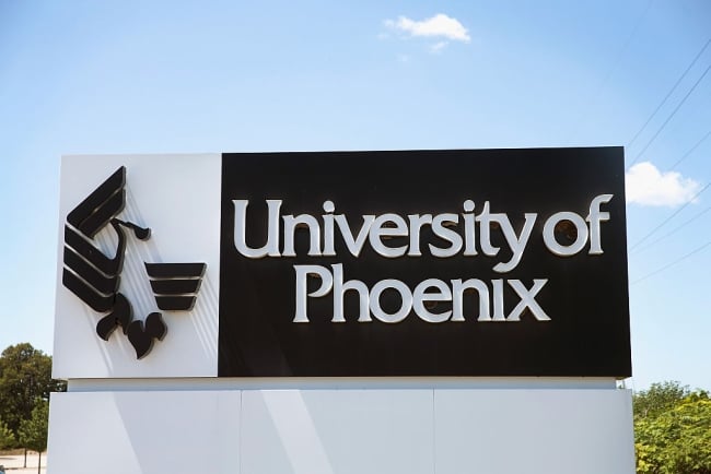 A sign bearing the University of Phoenix's name and logo.