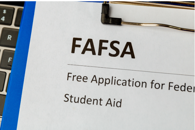 A printed FAFSA: Free Application for Federal Student Aid form, with a keyboard in the background.