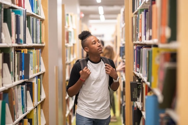 A young Black man in a library