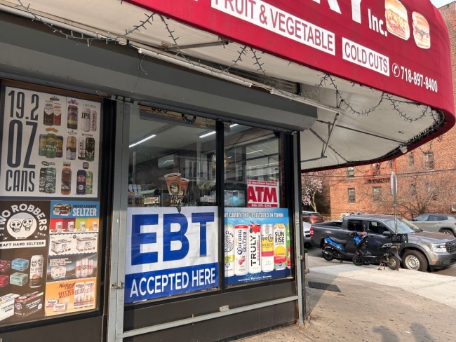 A sign saying "EBT accepted" sits in the window of a Queens, N.Y., bodega.