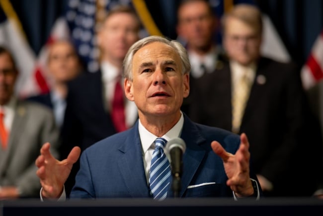 A photograph of Greg Abbott, governor of Texas, a white man with gray hair wearing a suit, looking upward.