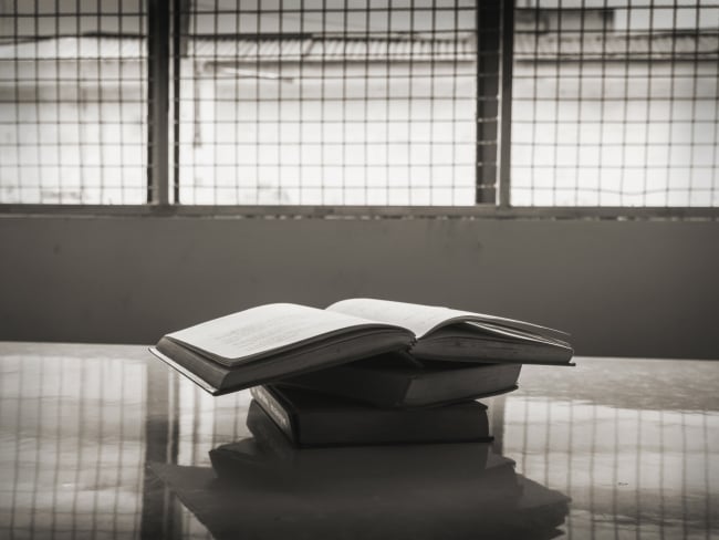 A stack of books in a prison room.