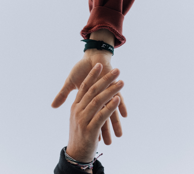 Two hands reach out to each other on a gray background