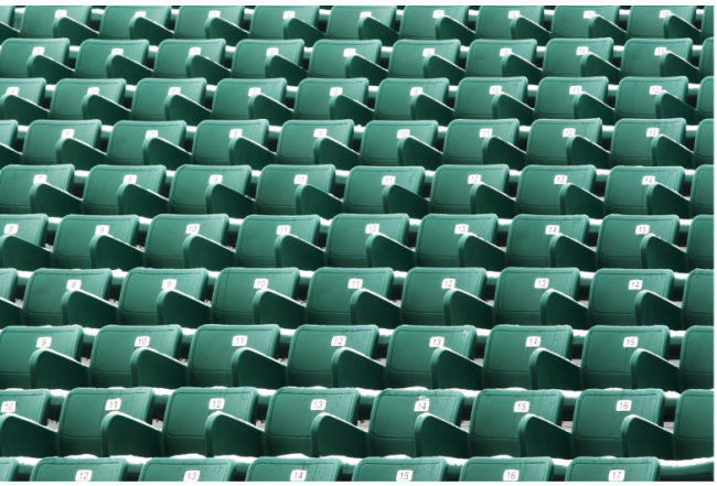 Rows of green stadium bleacher seats, suggesting "cheap" or "nosebleed" seats.