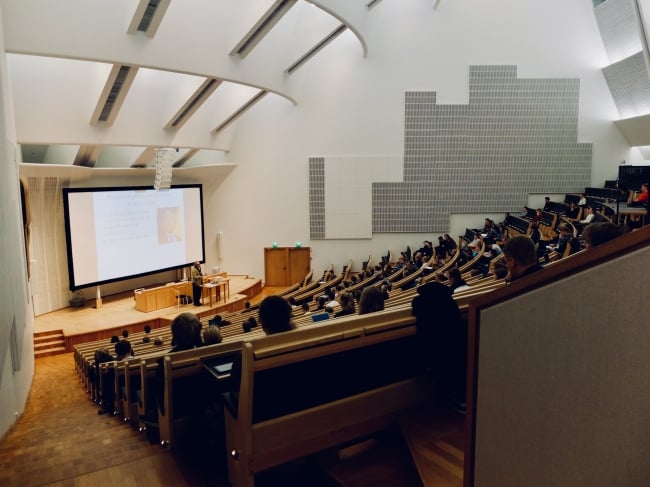 Students sit in a large lecture hall