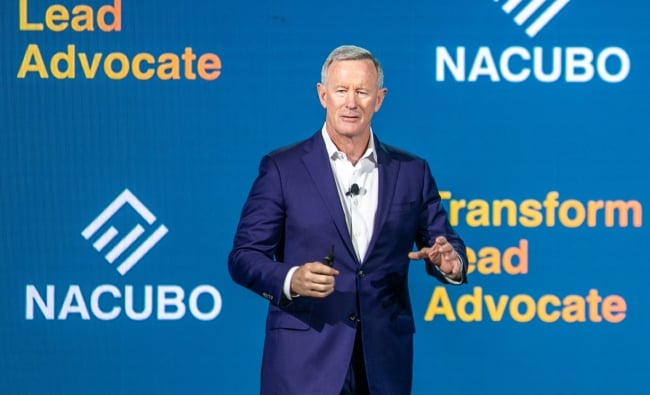 Bill McRaven, a white man with gray hair wearing a suit, speaks at NACUBO