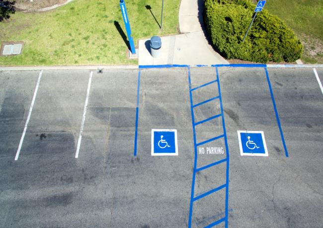 A parking lot has two designated spots for individuals with disabilities.