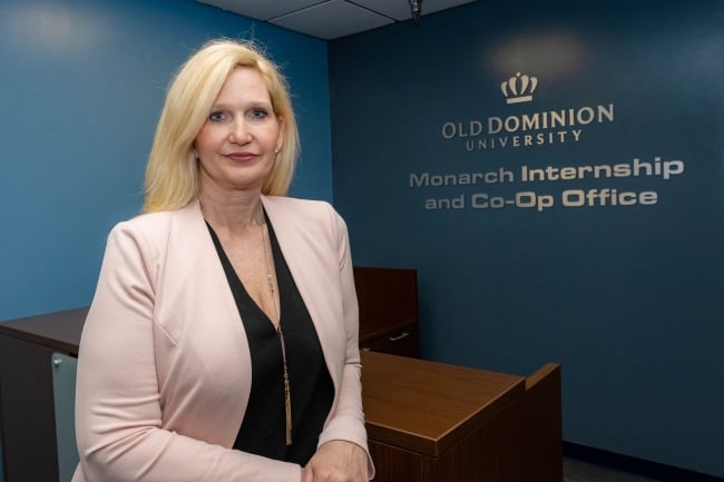 Barbara Blake Gonzalez stands in front of the Old Dominion University Monarch Internship and Co-Op office