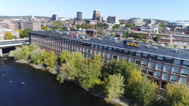 A aerial view of Southern New Hampshire University showing a building surrounded by trees.