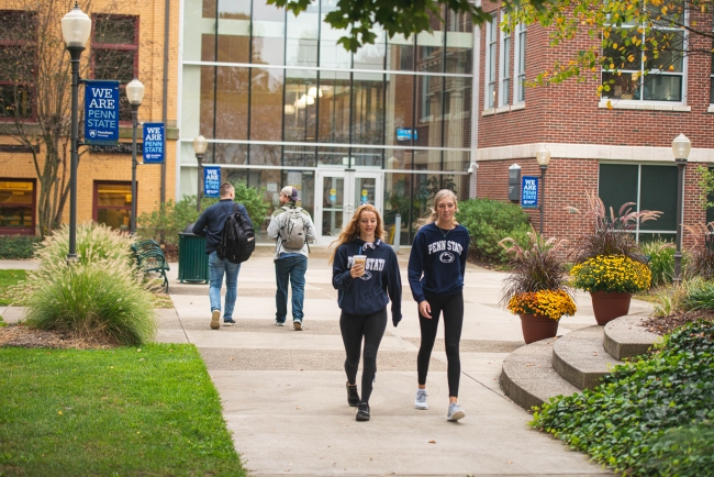 Students in Penn State sweatshirts walk on the Penn State Shenango campus.