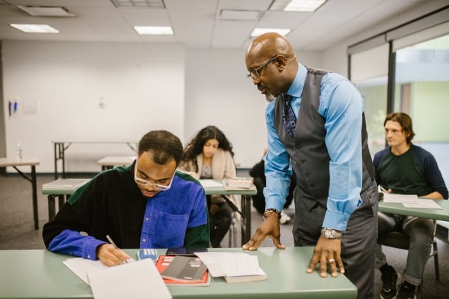 A professor offers advice to a student who is taking a test.