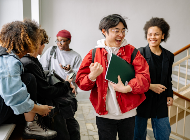 A group of students interact in a hallway.