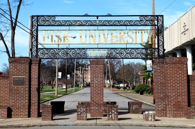 A brick gateway reads "Fisk University" in large, gold letters. 