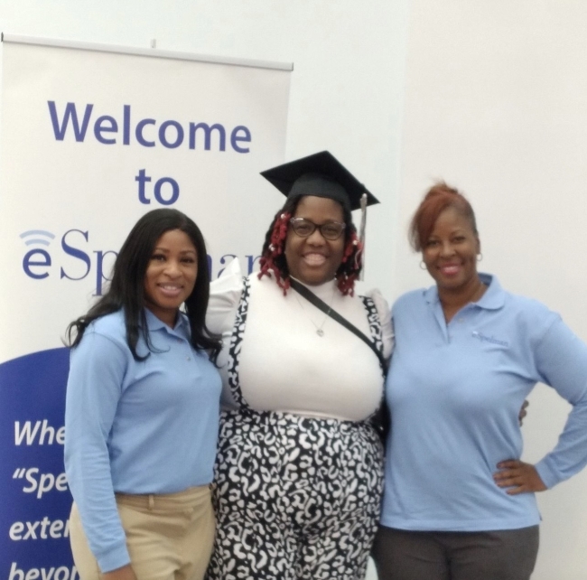 Three Black women, one of them wearing a graduation cap