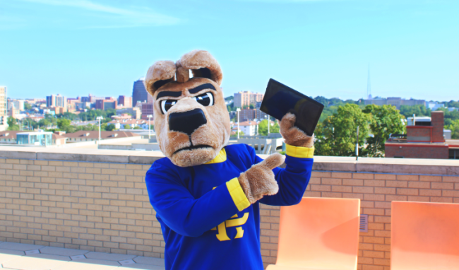 The University of Missouri Kansas City's mascot, a kangaroo, holds up a tablet on campus.