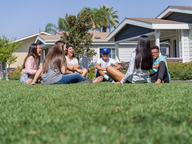 A group of students sits on a lawn at California Baptist University