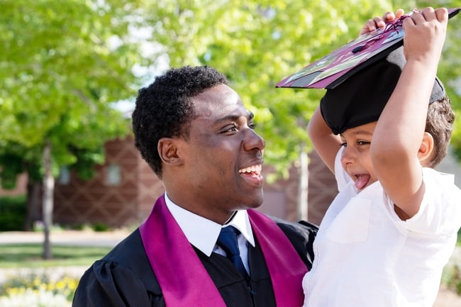 Black student father graduates and celebrates with his son
