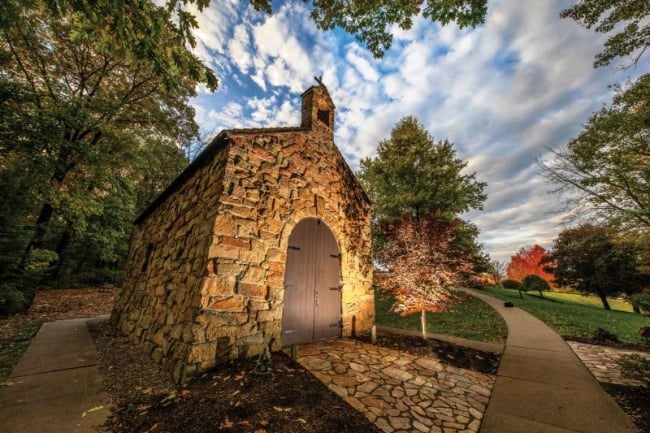 A stone building with a wooden door topped by a cross on Franciscan University of Steubenville's campus.
