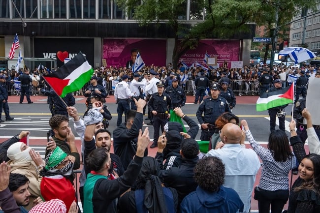 Palestinian supporters waving flags face off across a New York City street from a group of Israeli supporters waving flags