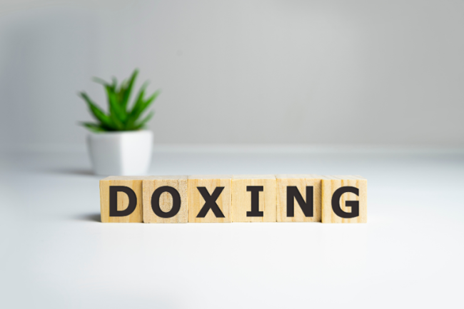 The word "Doxing" in block letters against a white background featuring a plant.