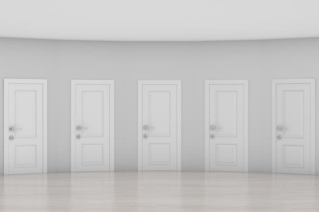 Pale gray hall with five white doors that look exactly the same