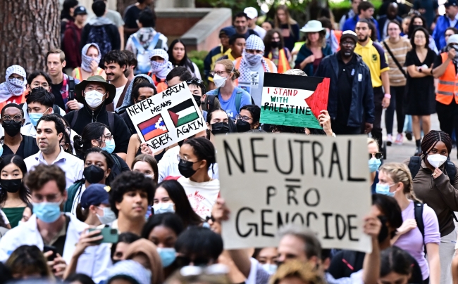 Pro-Palestinian students protest at UCLA. One holds a sign that reads "neutral = pro genocide."