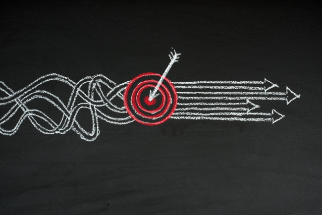 Garbled lines representing goals all lead to a target, after which arrows point toward the same direction.