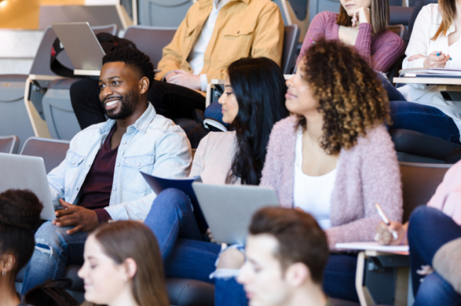 A racially diverse group of college students attends a lecture.