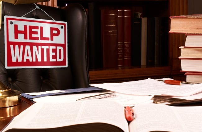 Photo illustration of an empty desk and Help Wanted sign