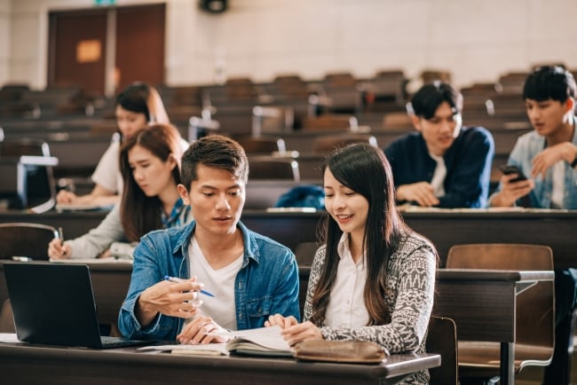 Multiethnic students doing exam in lecture hall