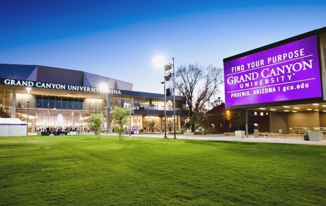 The campus of Grand Canyon University showing the front of an arena and a large electronic sign