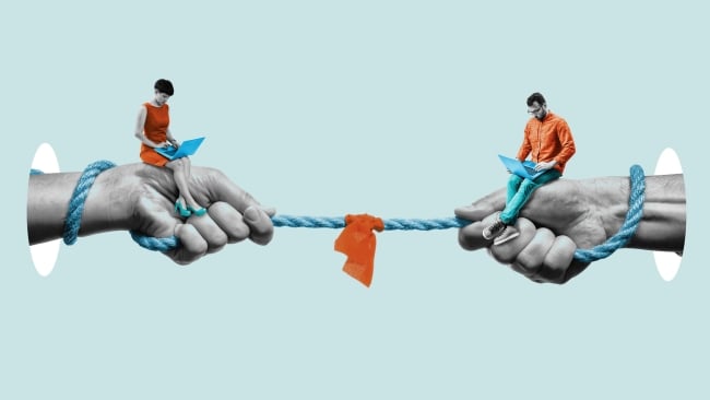 Two large hands are on the left and right side of the photo, each holding a smaller person that is looking at a laptop. There is a rope between the two large hands with an orange cloth in the middle of it.