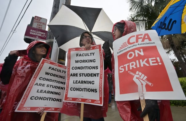 A photograph of strikers, holding umbrellas and signs, including one saying "CFA On Strike!" 