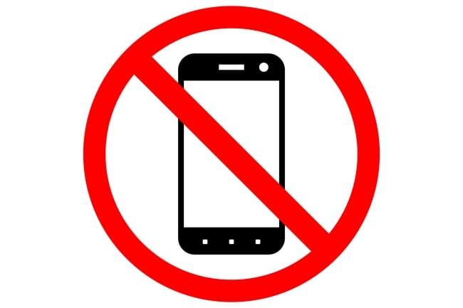 A sign prohibiting smartphone usage, featuring a black-and-white drawing of a smartphone inside a red circle with a diagonal slash through it.