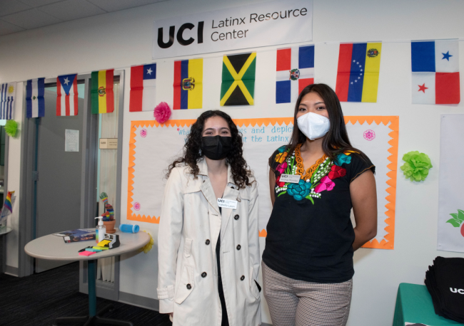 Two students wear masks in front of the UCI Latinx Resource Center.